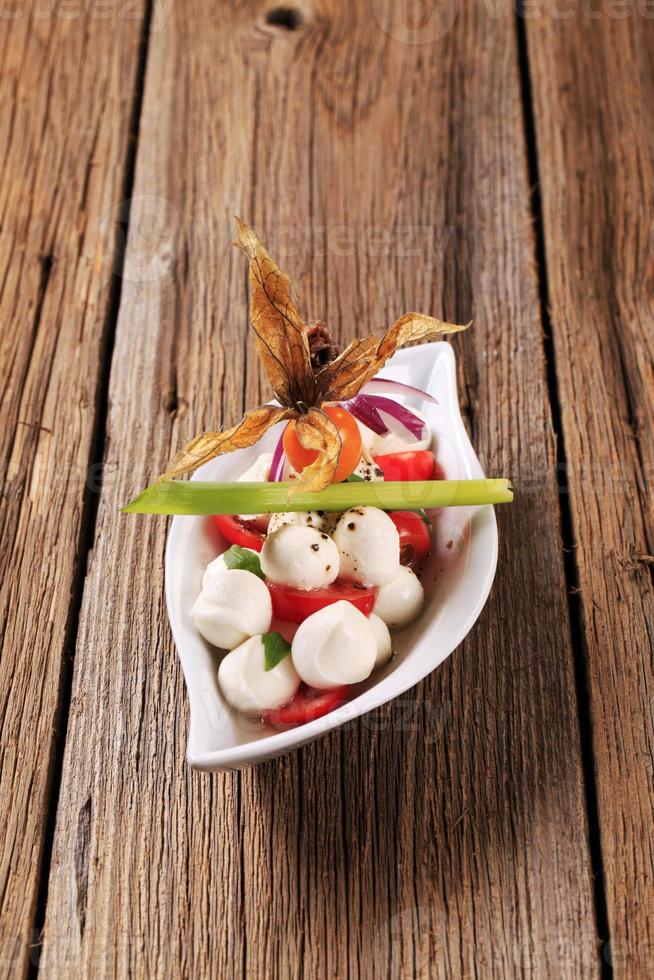 Bowl of mozzarella cheese, tomato and basil photo