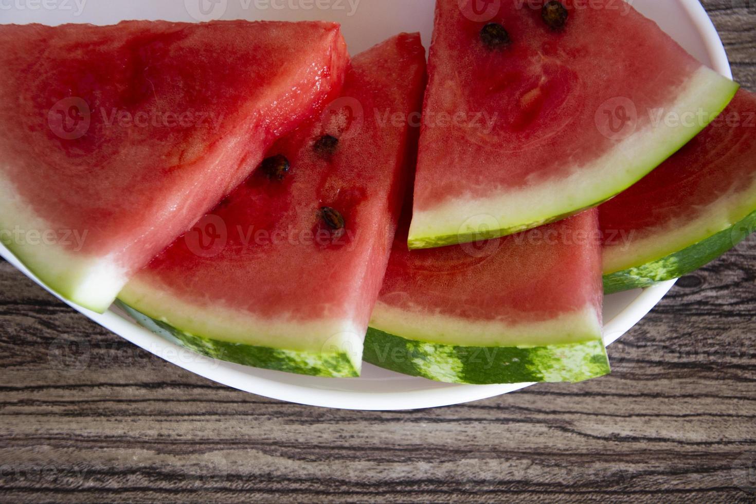 Slices of ripe watermelon lie on a white plate photo