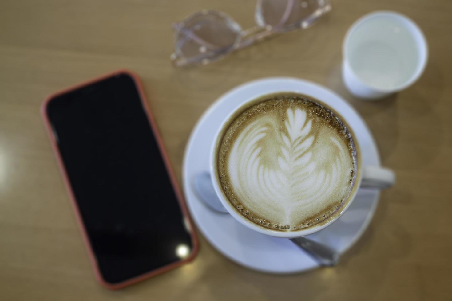 Coffee cup hot latte on wooden table photo