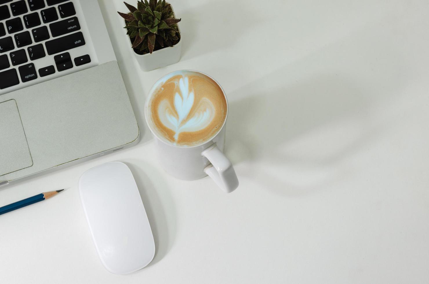 Top view mouse computer laptop and pencil coffee cup on desk. photo