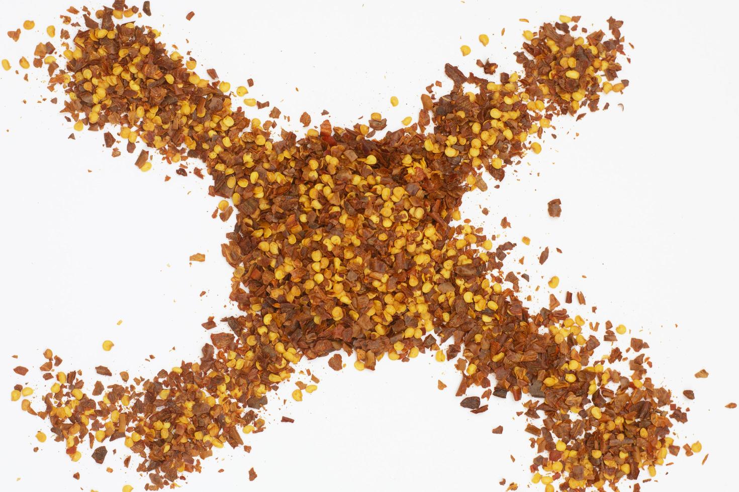 Dried red pepper flakes isolated on white, top view photo