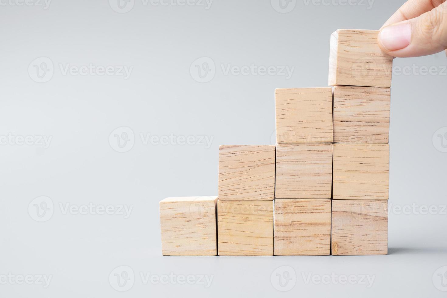 hand placing or pulling wooden block photo