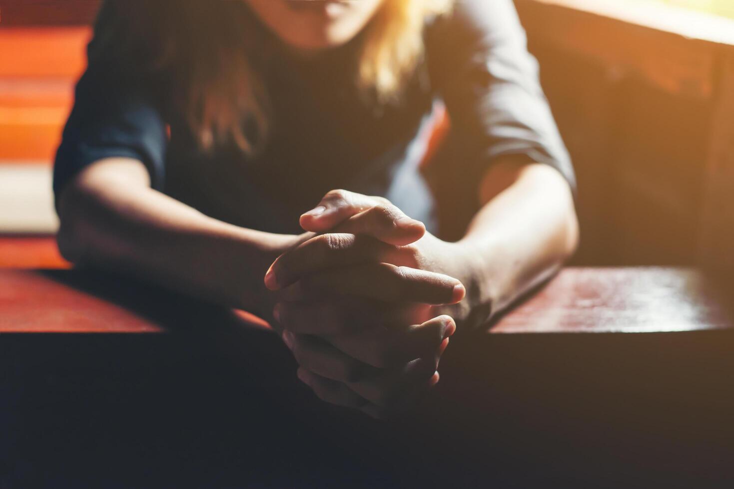 Praying woman sitting on bench. photo