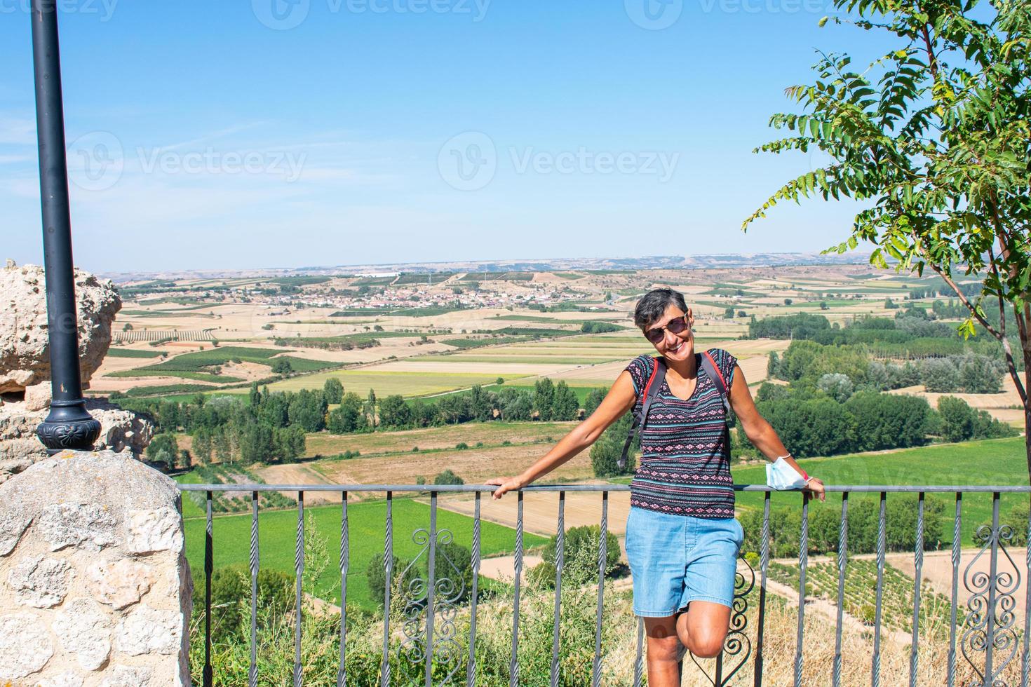 smiling woman leaning on a metal railing photo