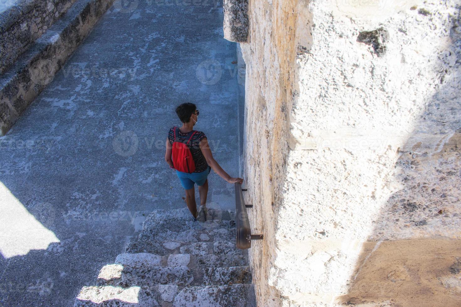 woman descending the stairs of a medieval church photo