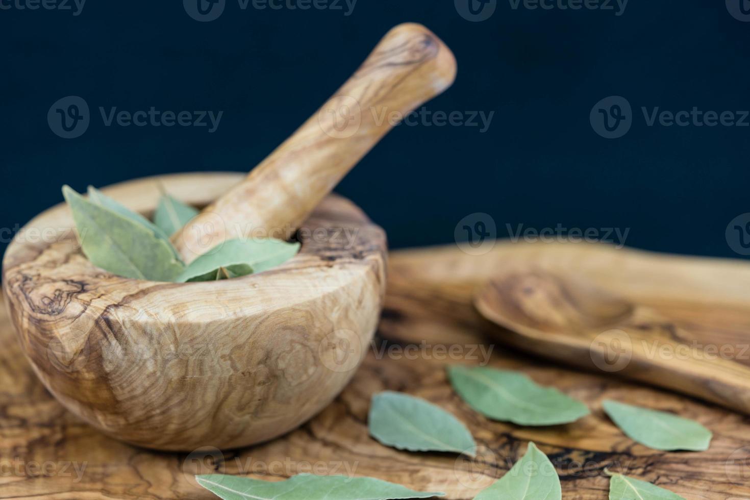 hojas de laurel y bayas de enebro en madera de olivo foto