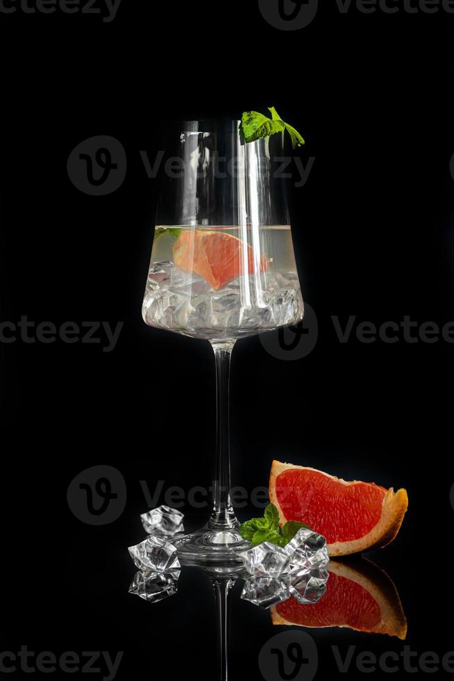 Cocktail with grapefruit on a dark background with a sprig of mint photo