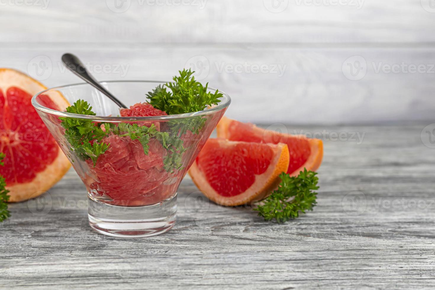 Summer salad with grapefruit on a light background with herbs. photo
