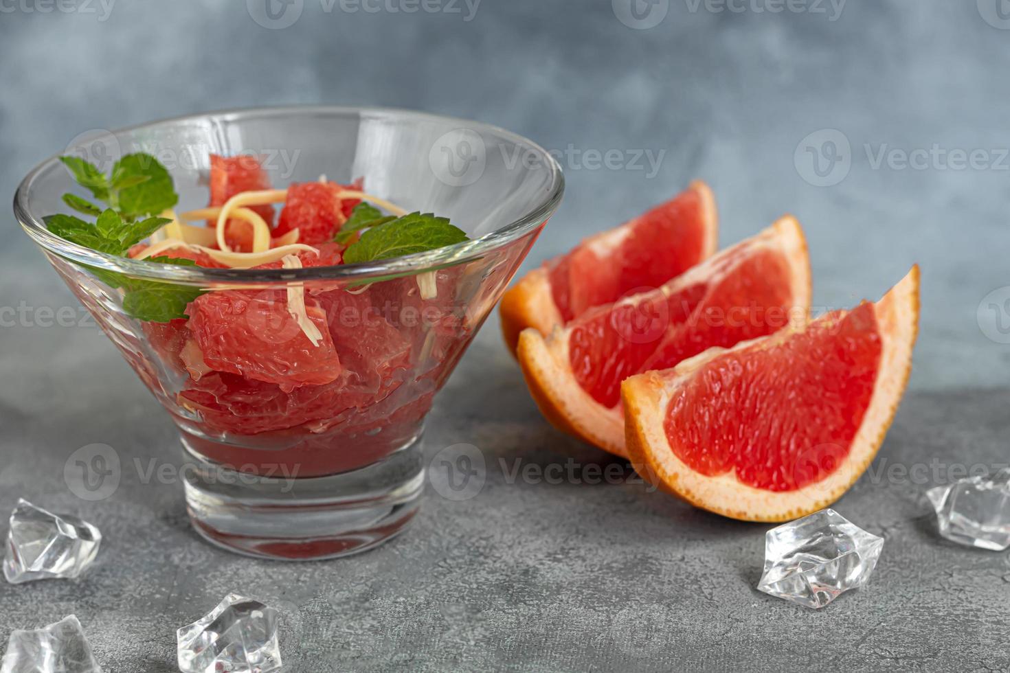 Summer salad with grapefruit on a light background with herbs. photo