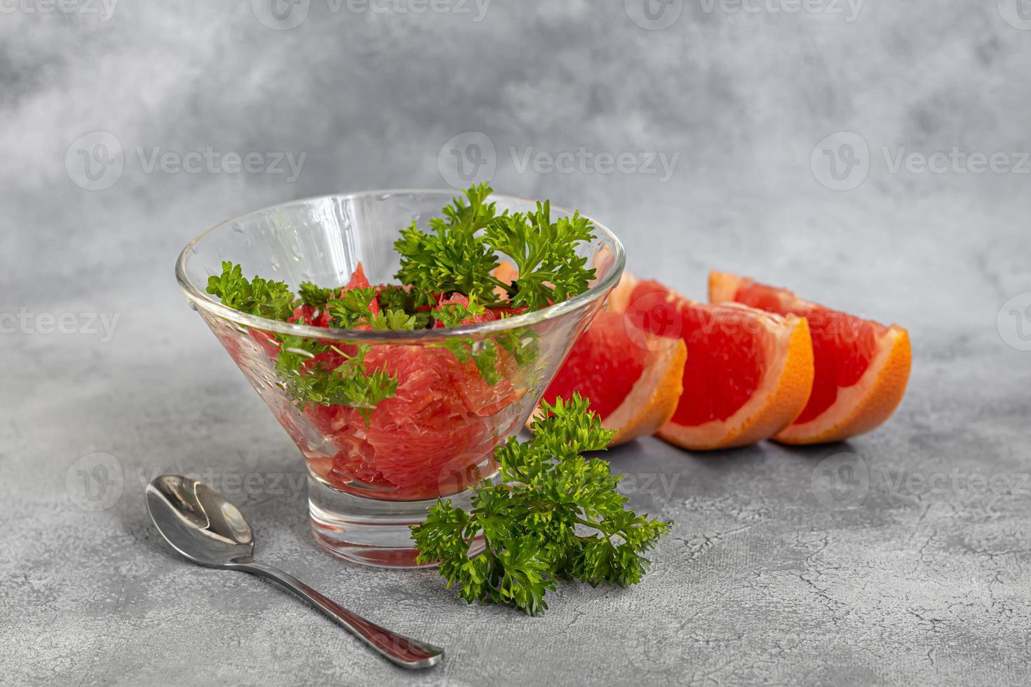 Summer salad with grapefruit on a light background with herbs. photo