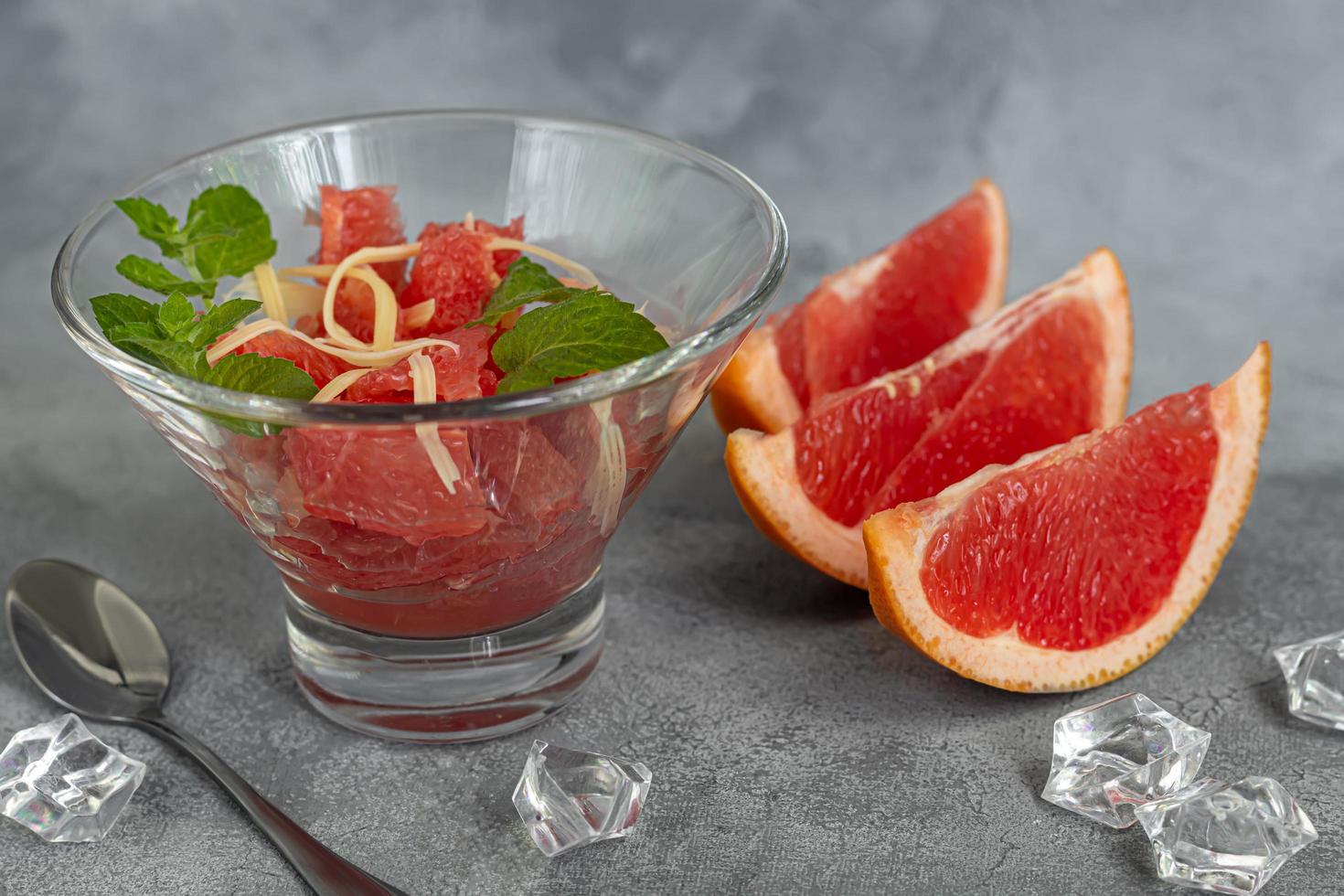 Summer salad with grapefruit on a light background with herbs. photo