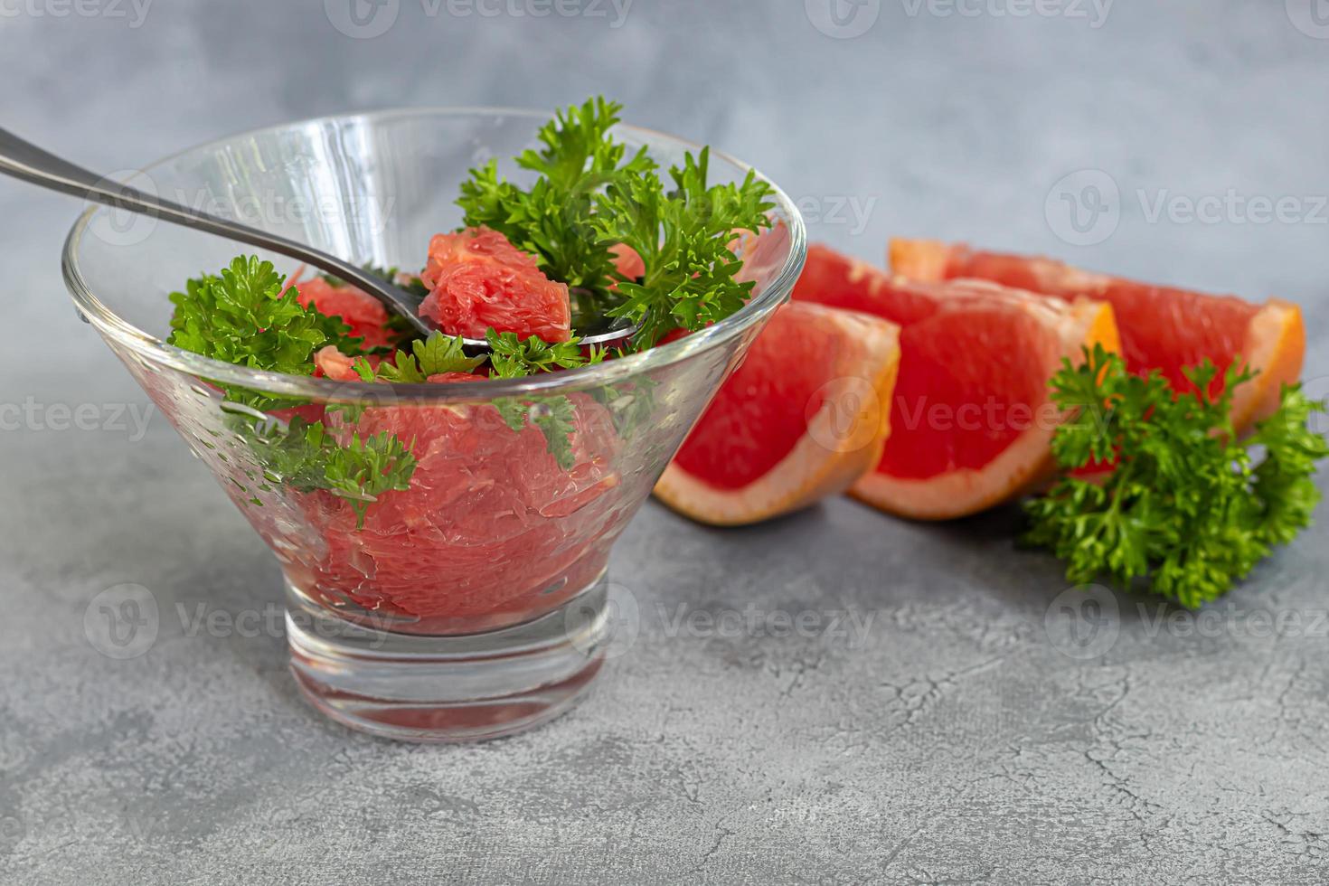 Summer salad with grapefruit on a light background with herbs. photo
