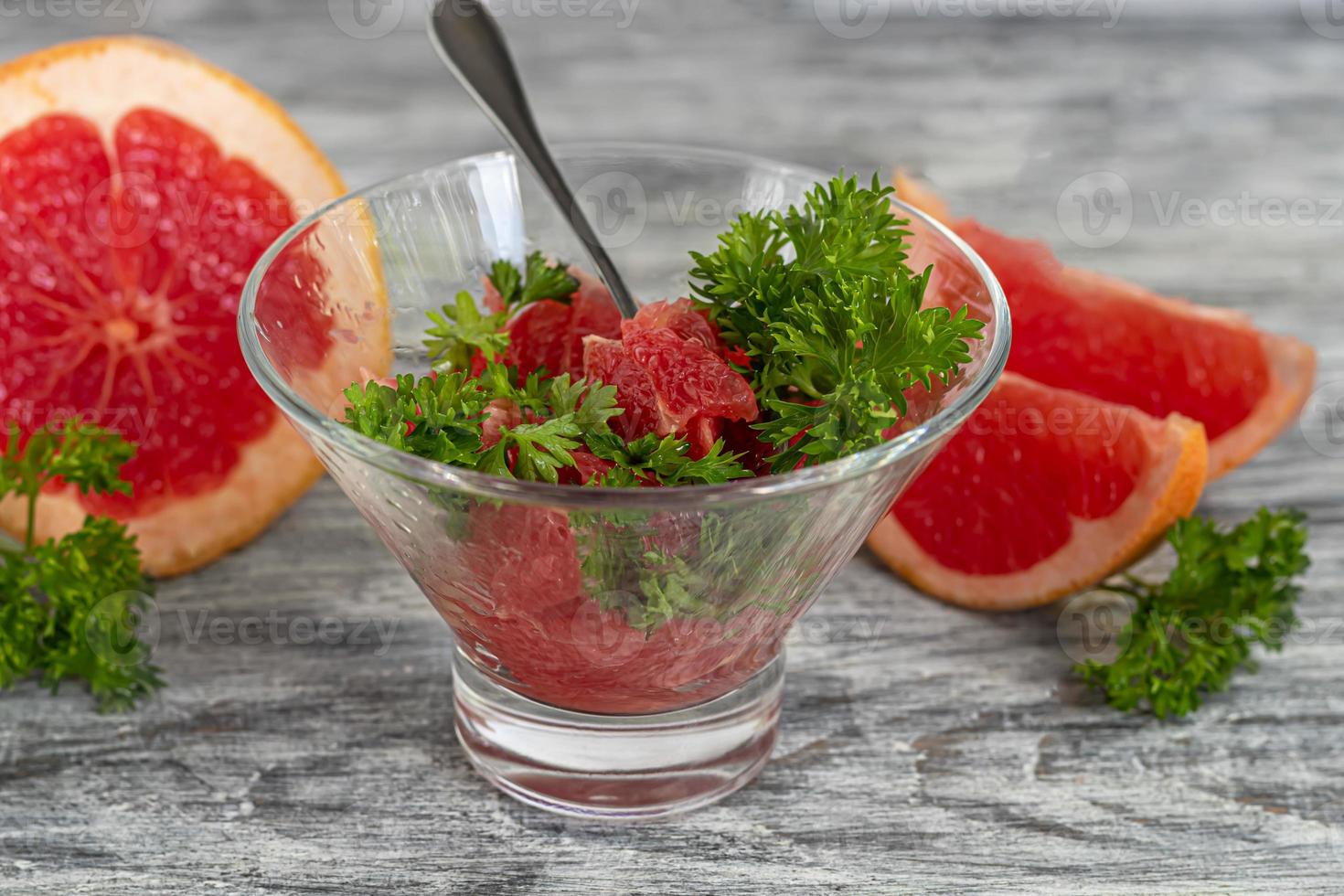 Summer salad with grapefruit on a light background with herbs. photo