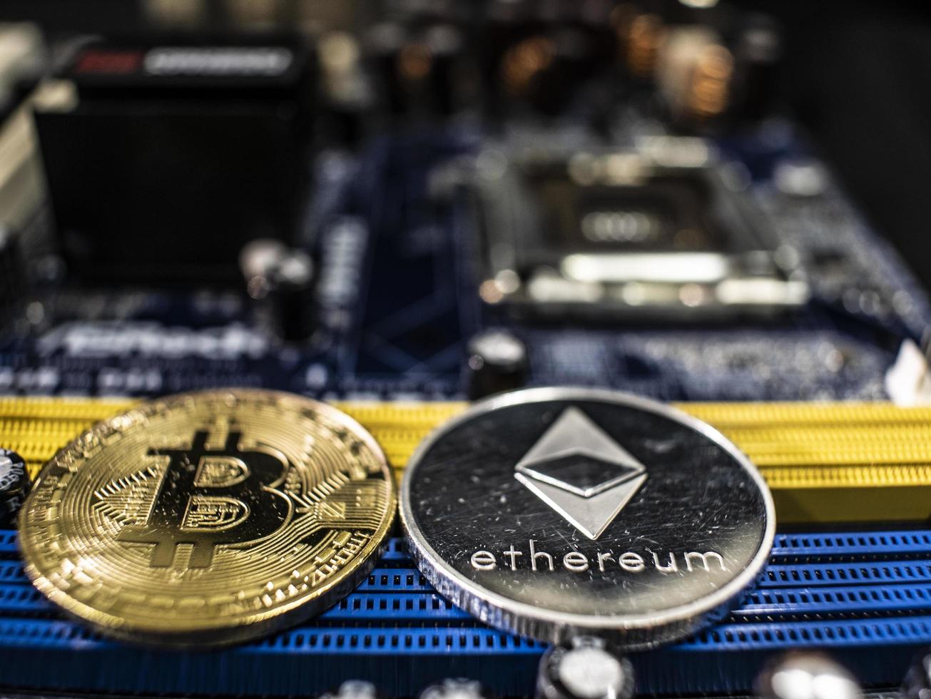 Coins of ethereum and bitcoin on the background of the chip photo