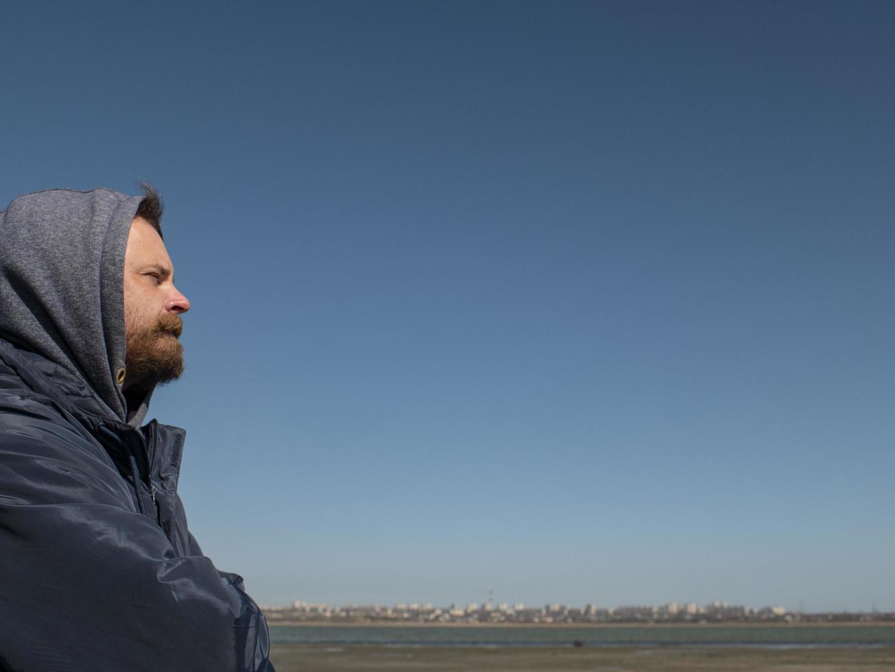 man hipster with a beard and mustache in the hood photo