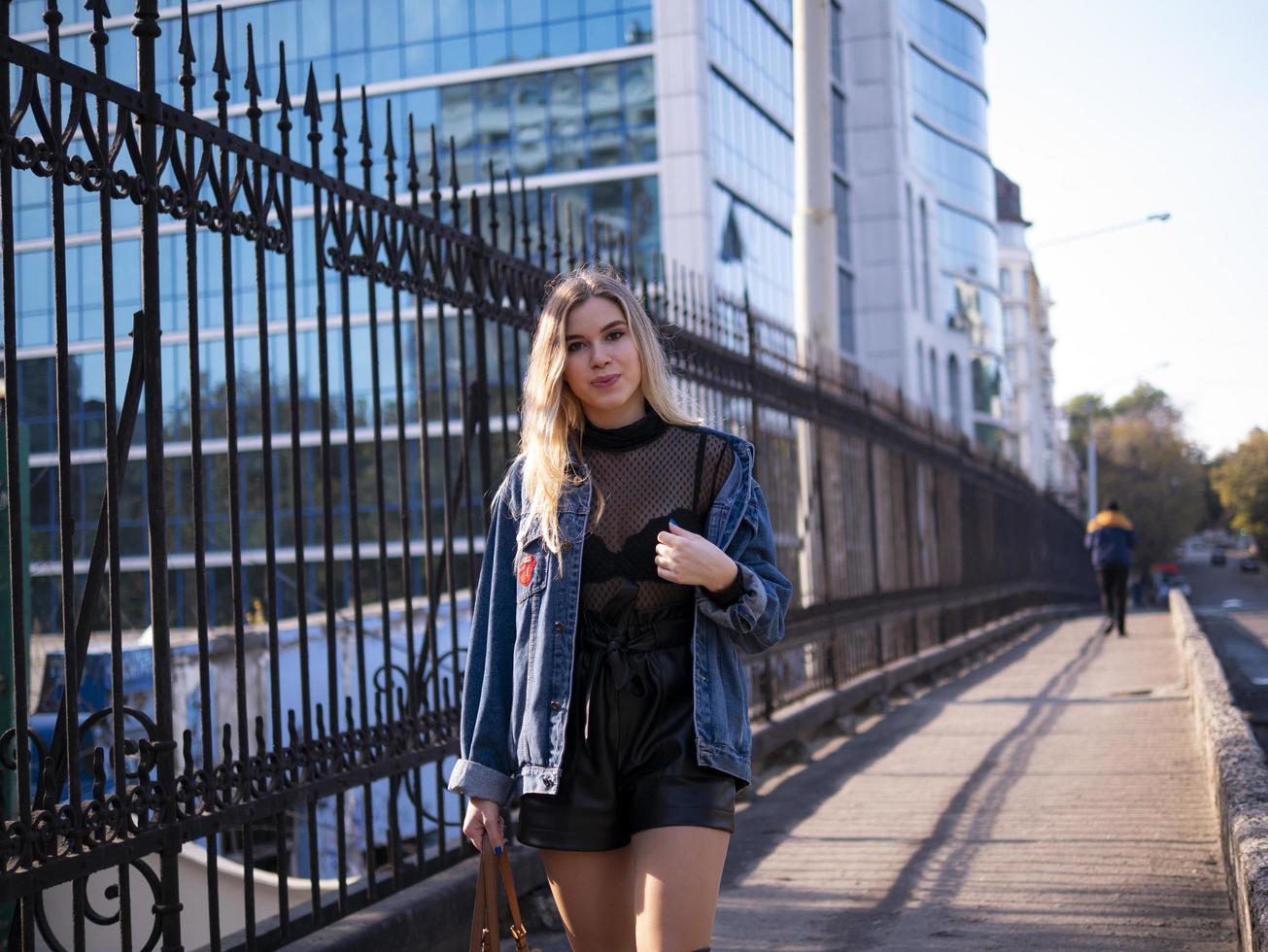 cute blonde with flowing hair in a denim jacket on the bridge outdoor photo