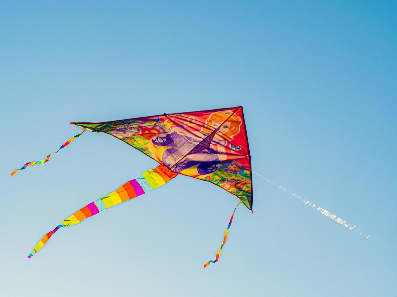 Colorful Cite Flying In The Wind Blue Sky. Flying A Kite Up High. photo