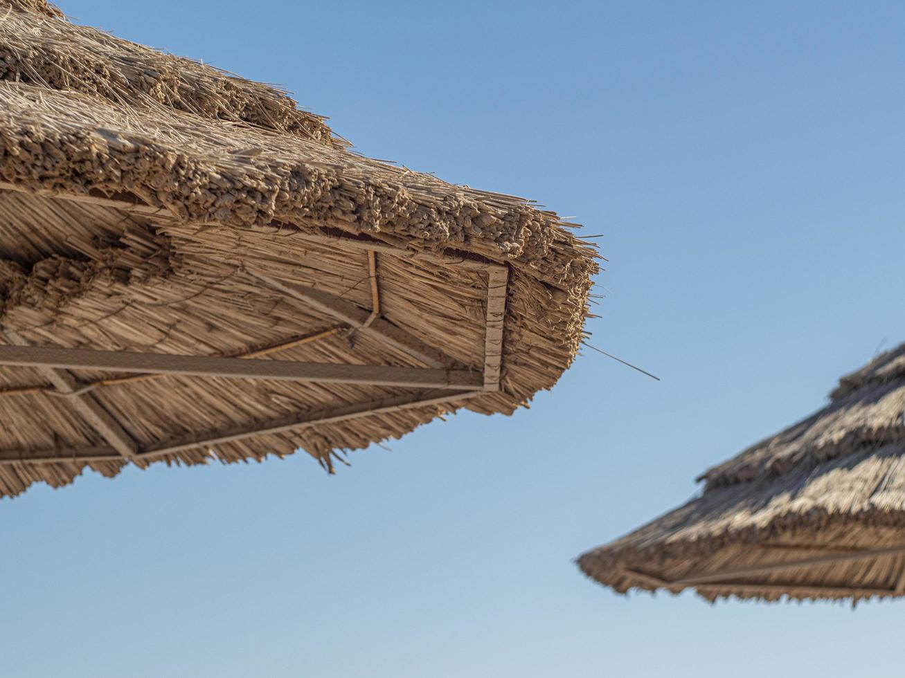 Straw Roof Of Beach Umbrella And Blue Sky In Background photo