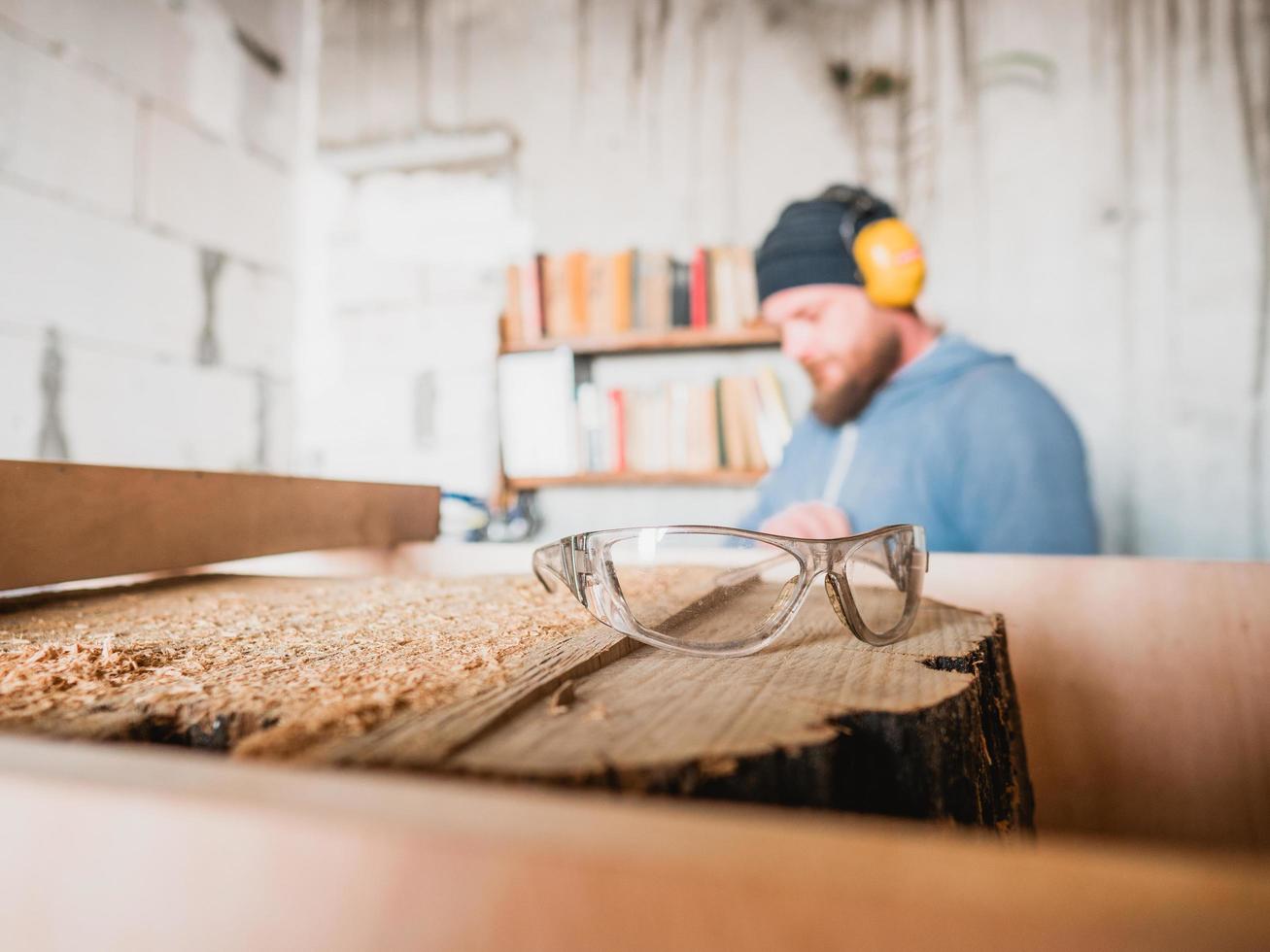 Gafas de seguridad de carpintero en tocón de madera. taller de carpinteria foto