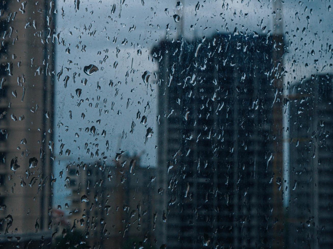 gotas de lluvia en la ventana. ventana mojada luces de la ciudad gotas de lluvia foto