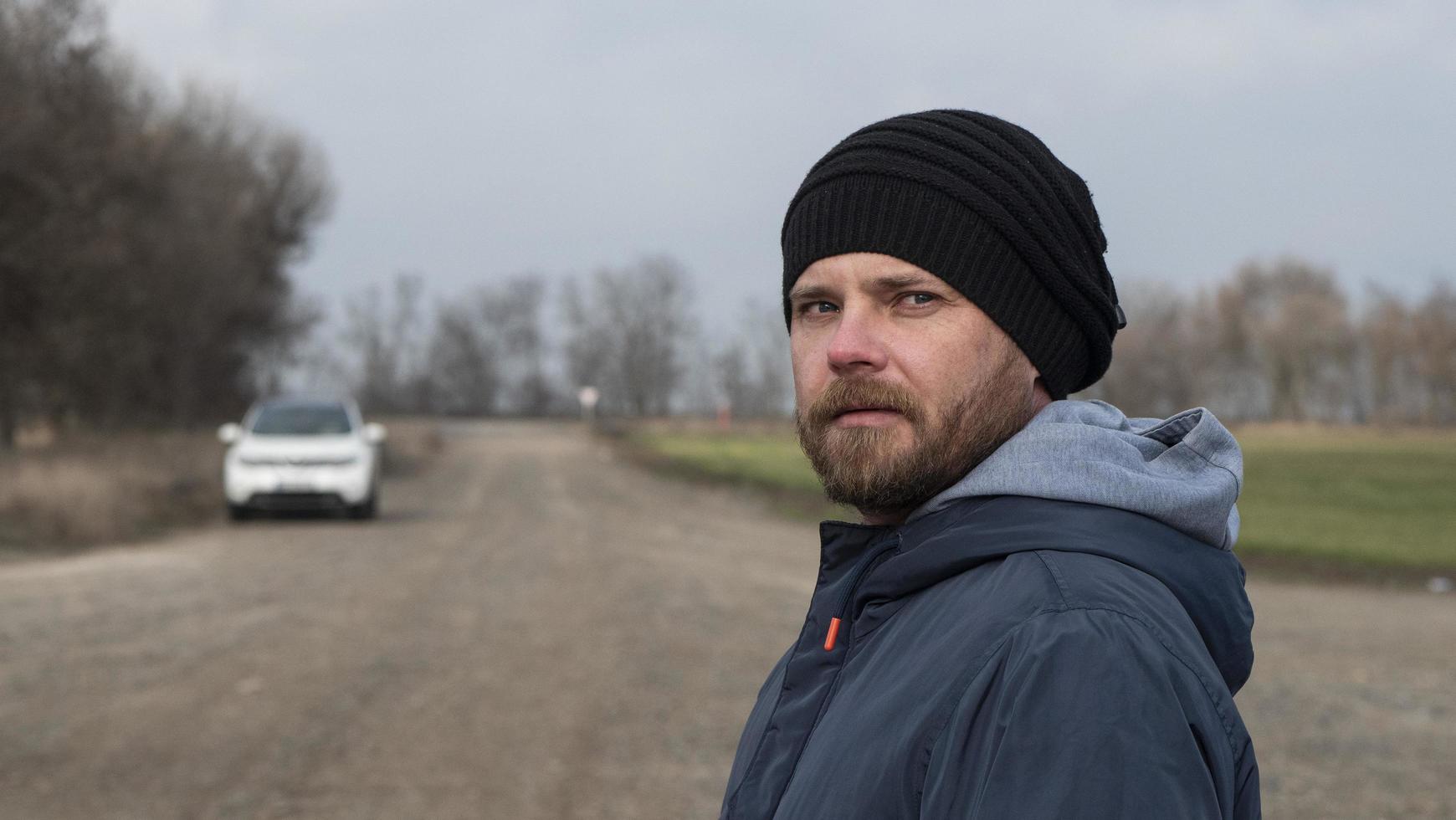 Portrait Of An Attractive Hipster Man With A Beard In A Knitted Hat photo