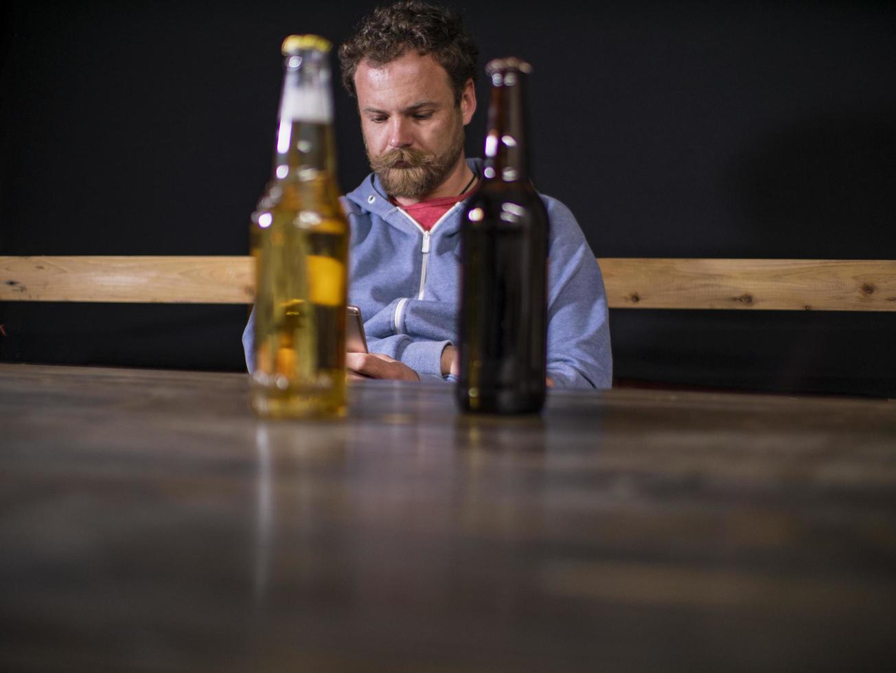 dos botellas de cerveza están de pie sobre la mesa foto