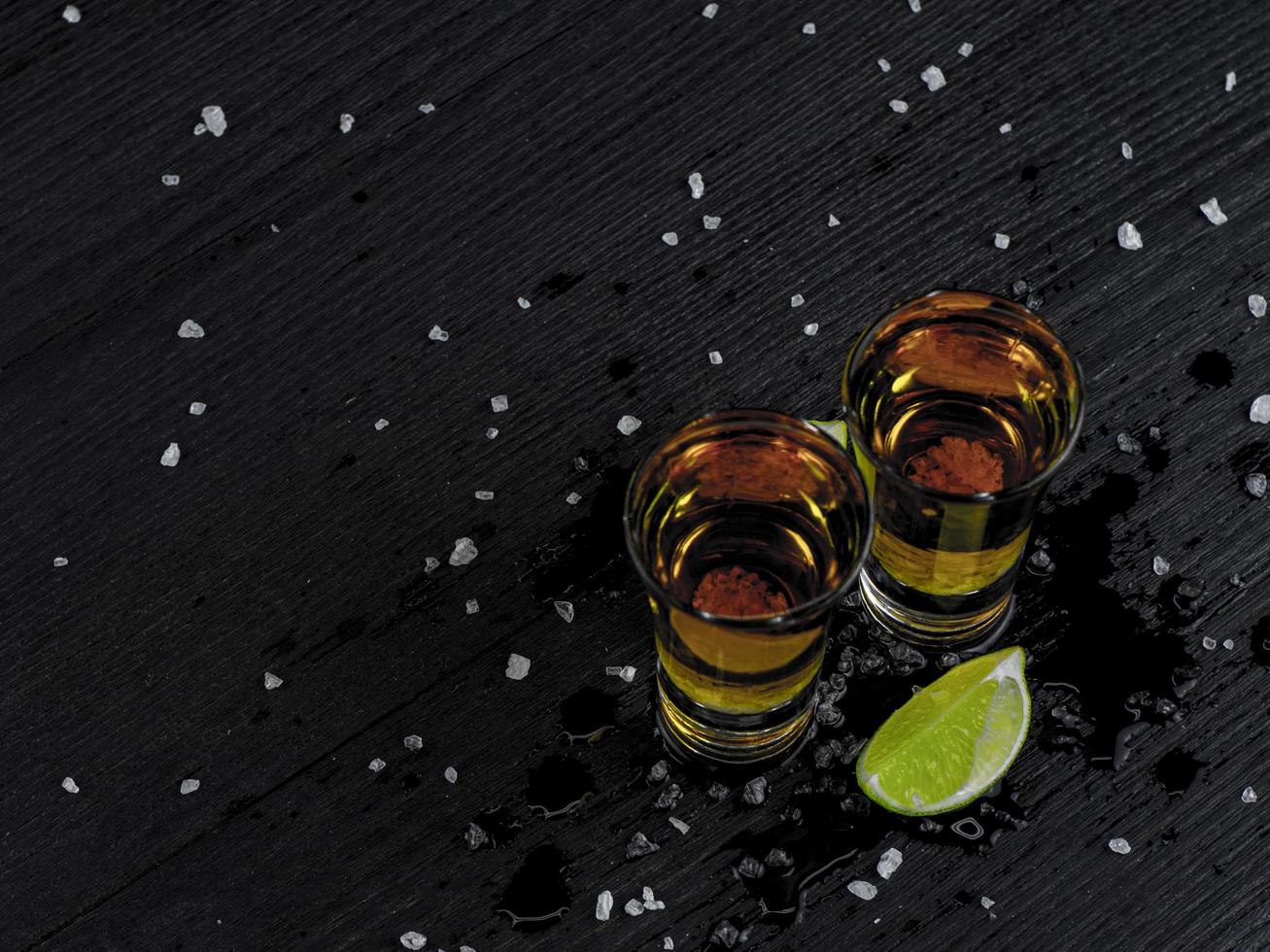 Two shots tequila gold with juicy lime and sea salt photo