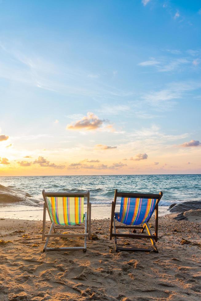 Summer vacation deckchairs on tropical beach photo