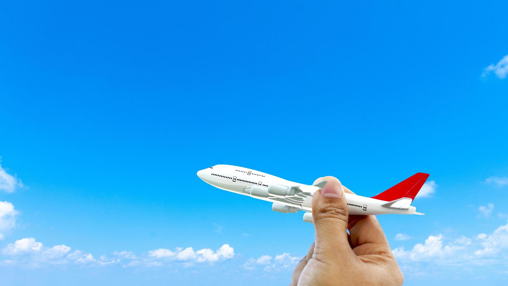 Miniature toy airplane flying on cloud blue sky background photo