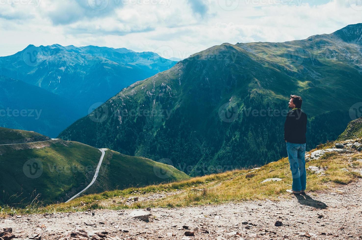 turista hombre de pie en la cima de la montaña foto