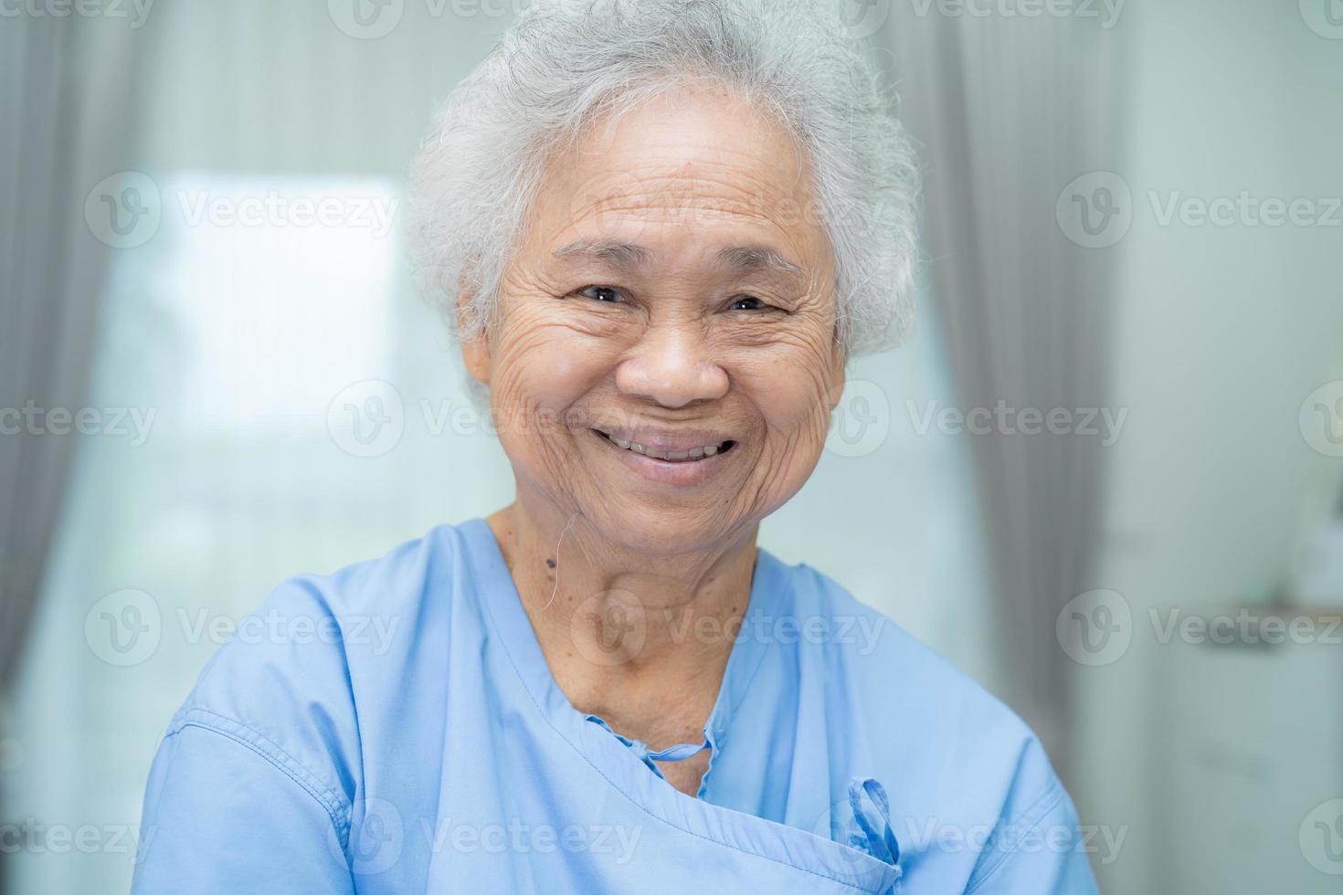 Paciente mujer senior asiática sonrisa cara brillante en el hospital de enfermería foto