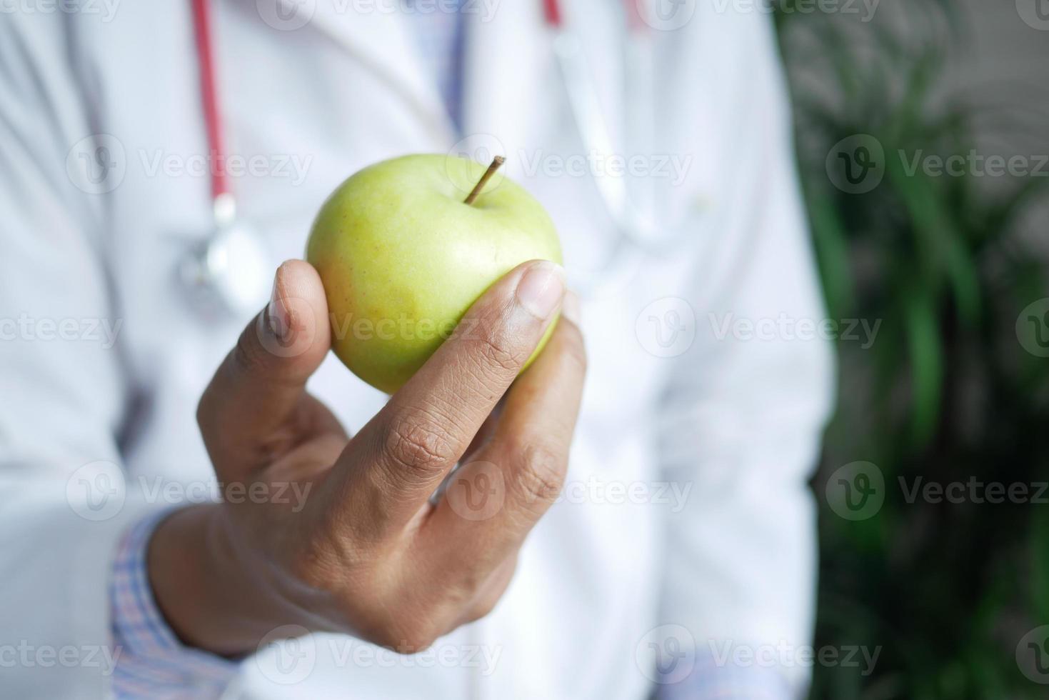 doctor hand holding green apple close up photo