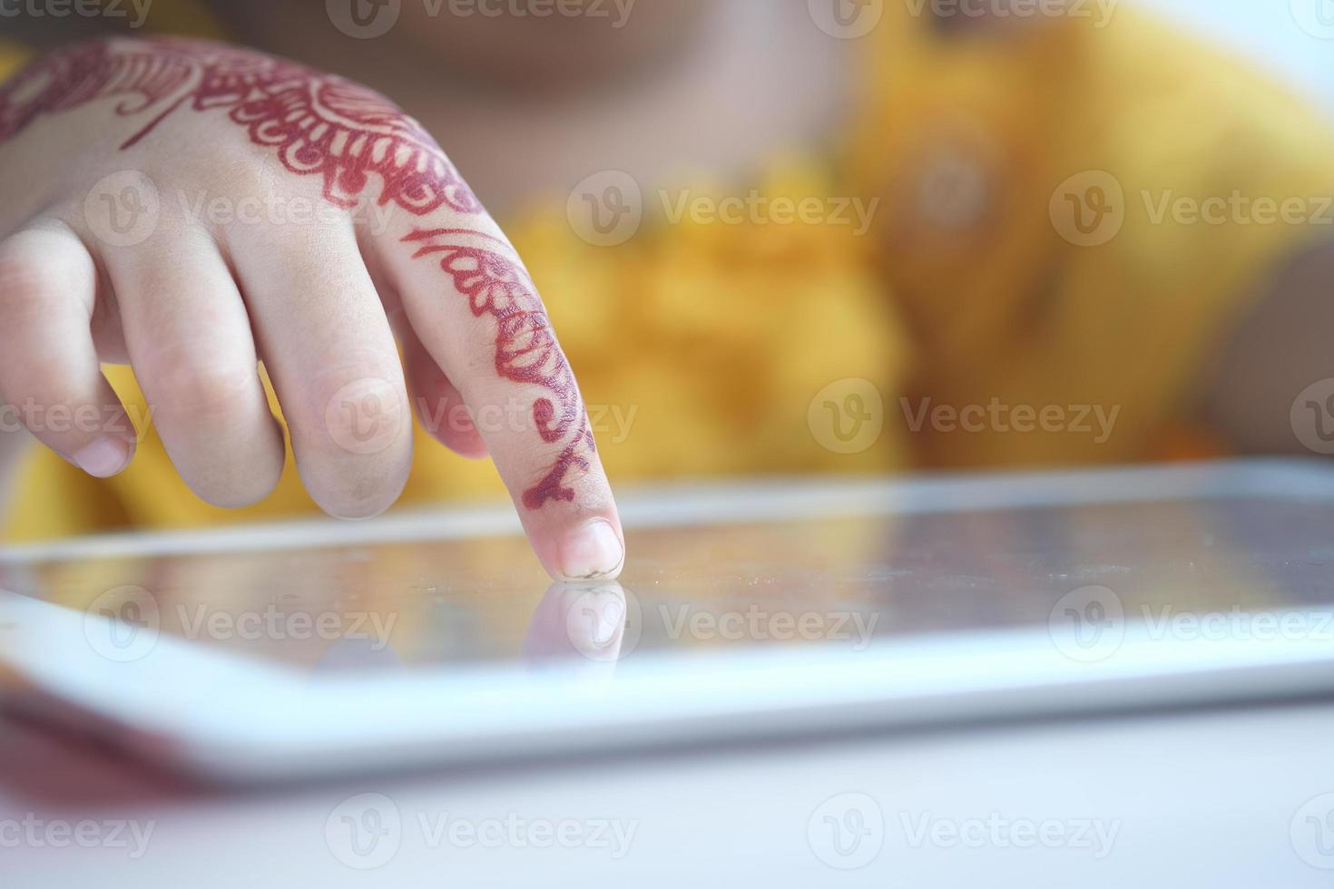 child hand pointing finger on digital tablet screen. photo