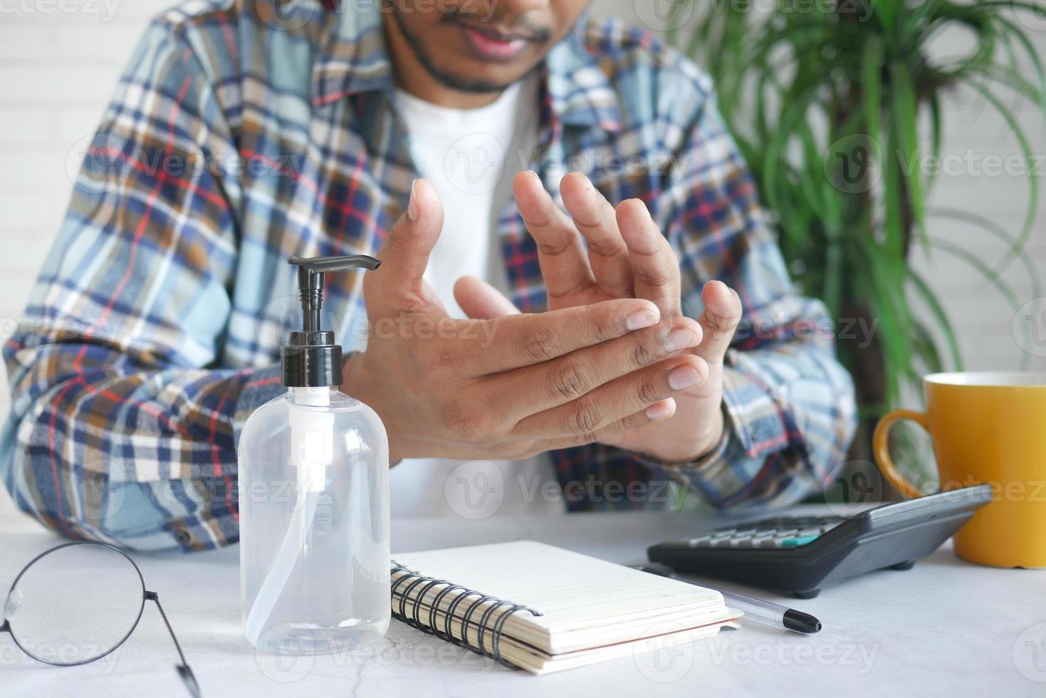 young man using hand sanitizer white sited photo