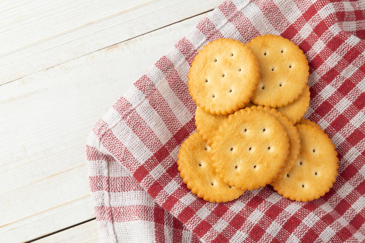 Cracker cookies with tablecloth on white wooden table background photo