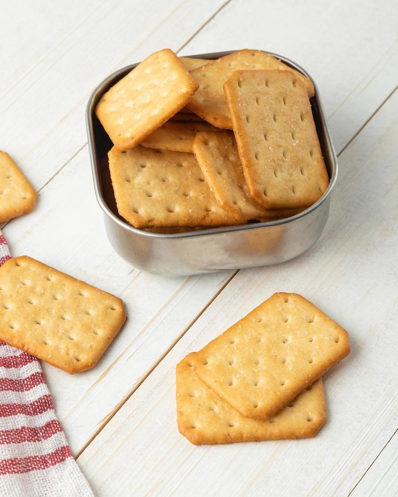 galletas saladas en un recipiente de acero inoxidable con mantel foto