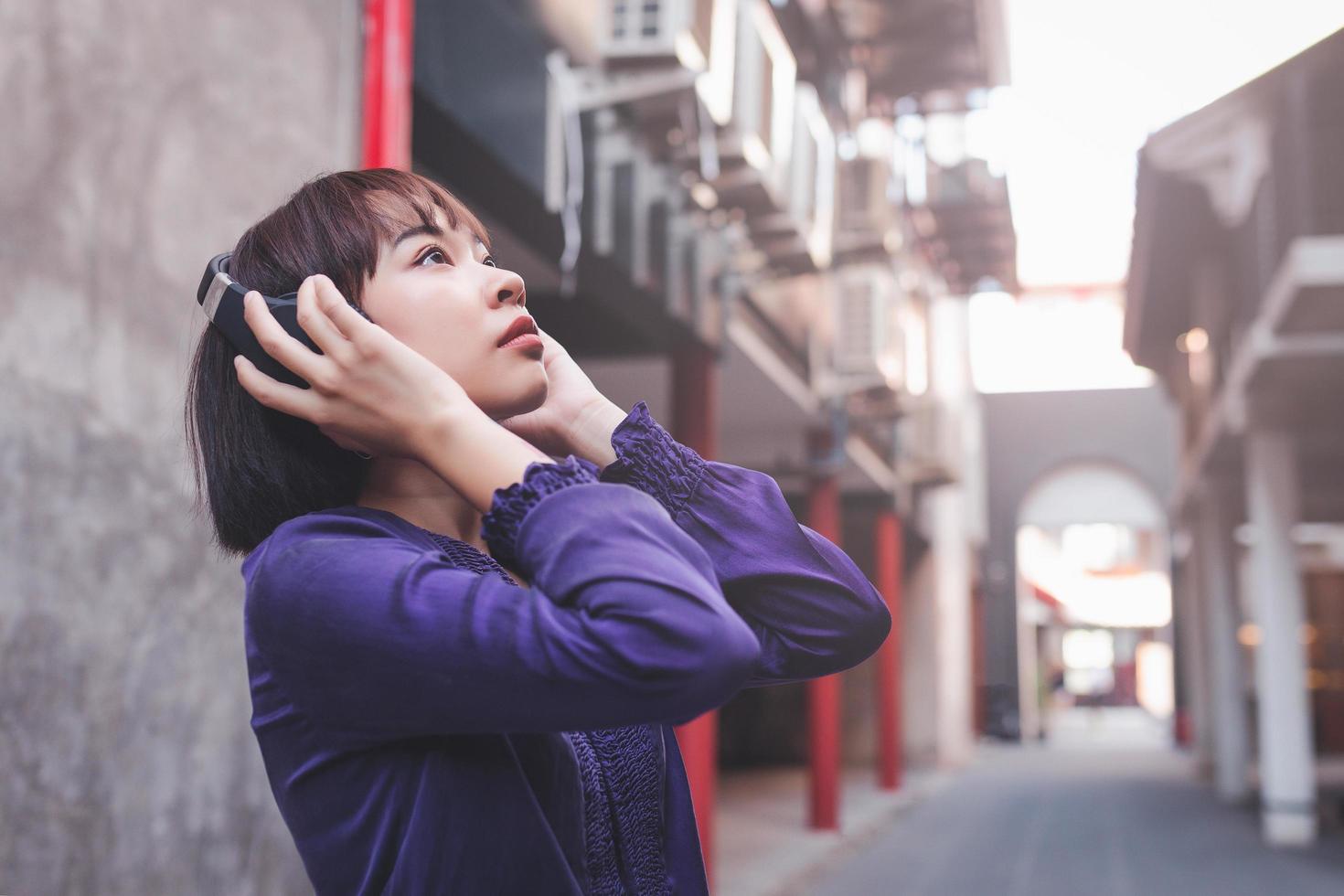 Happy young asian woman listening to music with headphones photo