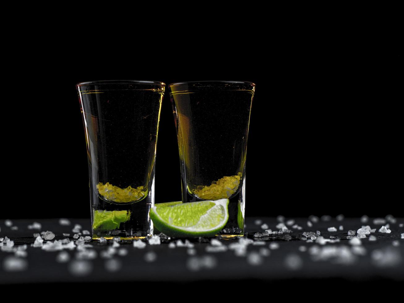 Two tequila shots gold with juicy lime and sea salt photo
