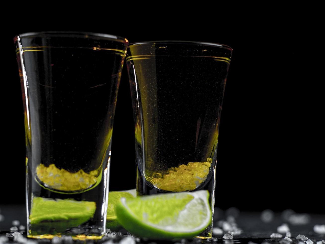 Two shots tequila gold with juicy lime and sea salt photo