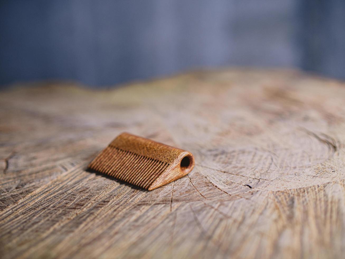 peine para barba hecho a mano sobre un tocón de madera foto