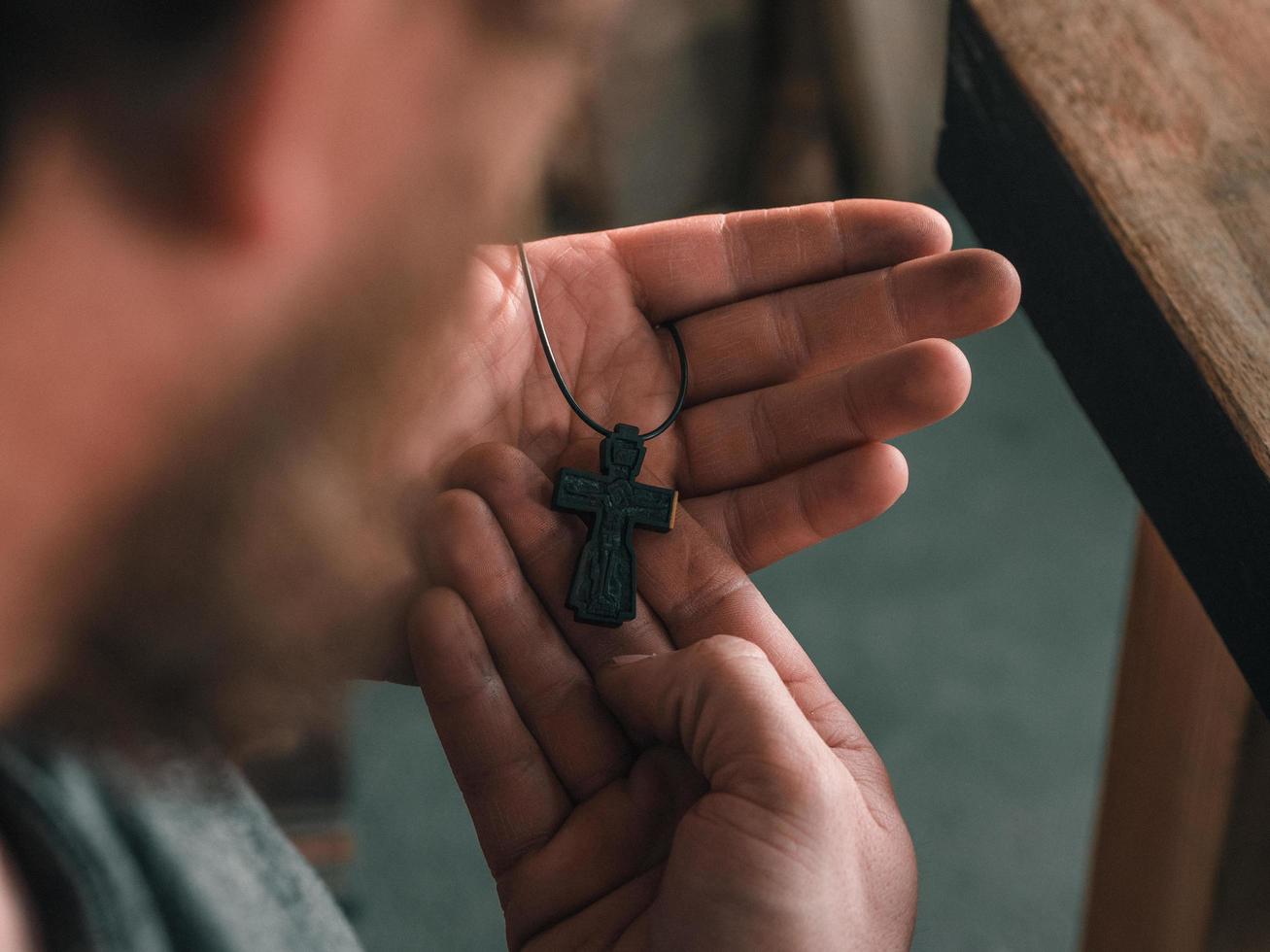 Hombre barbudo sosteniendo una cruz ortodoxa de madera en su mano foto