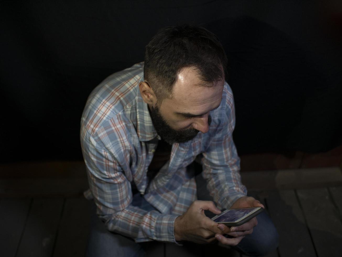 stylish man looks at the mobile phone screen photo