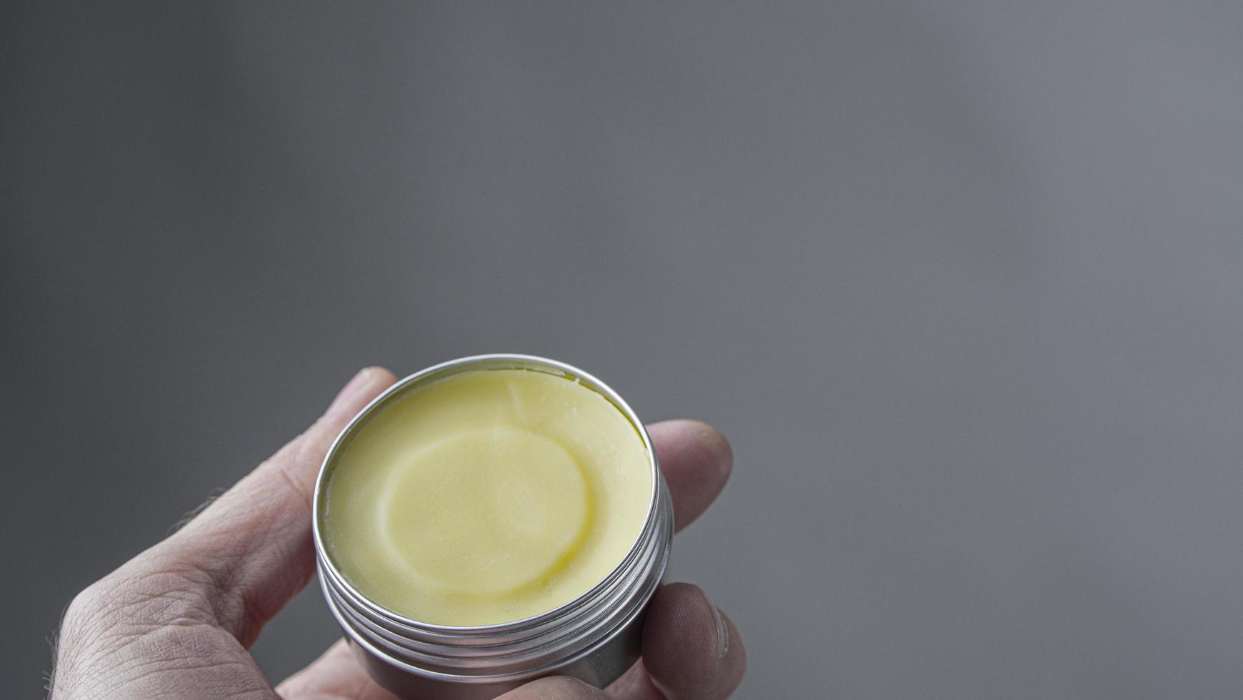 Male Hand Holds A Metal Jar With Wax For A Beard And Mustache photo