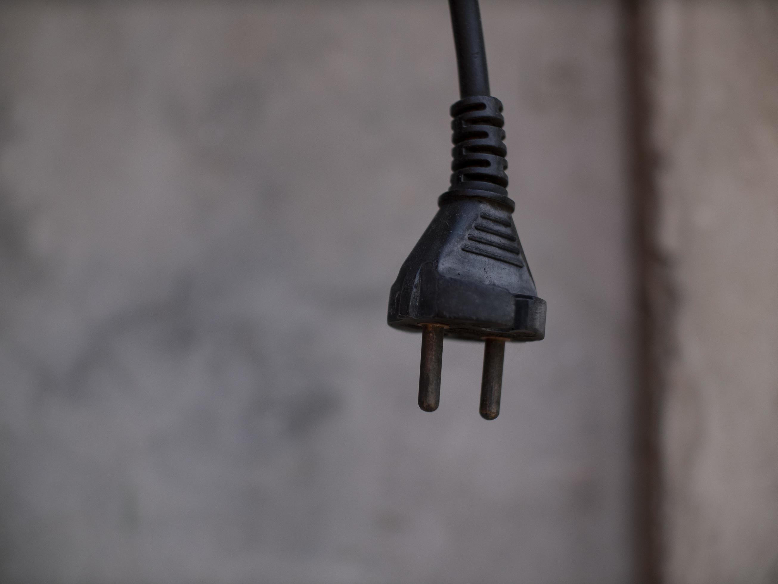 the plug from the socket hangs on the cord outdoor 3173094 Stock Photo