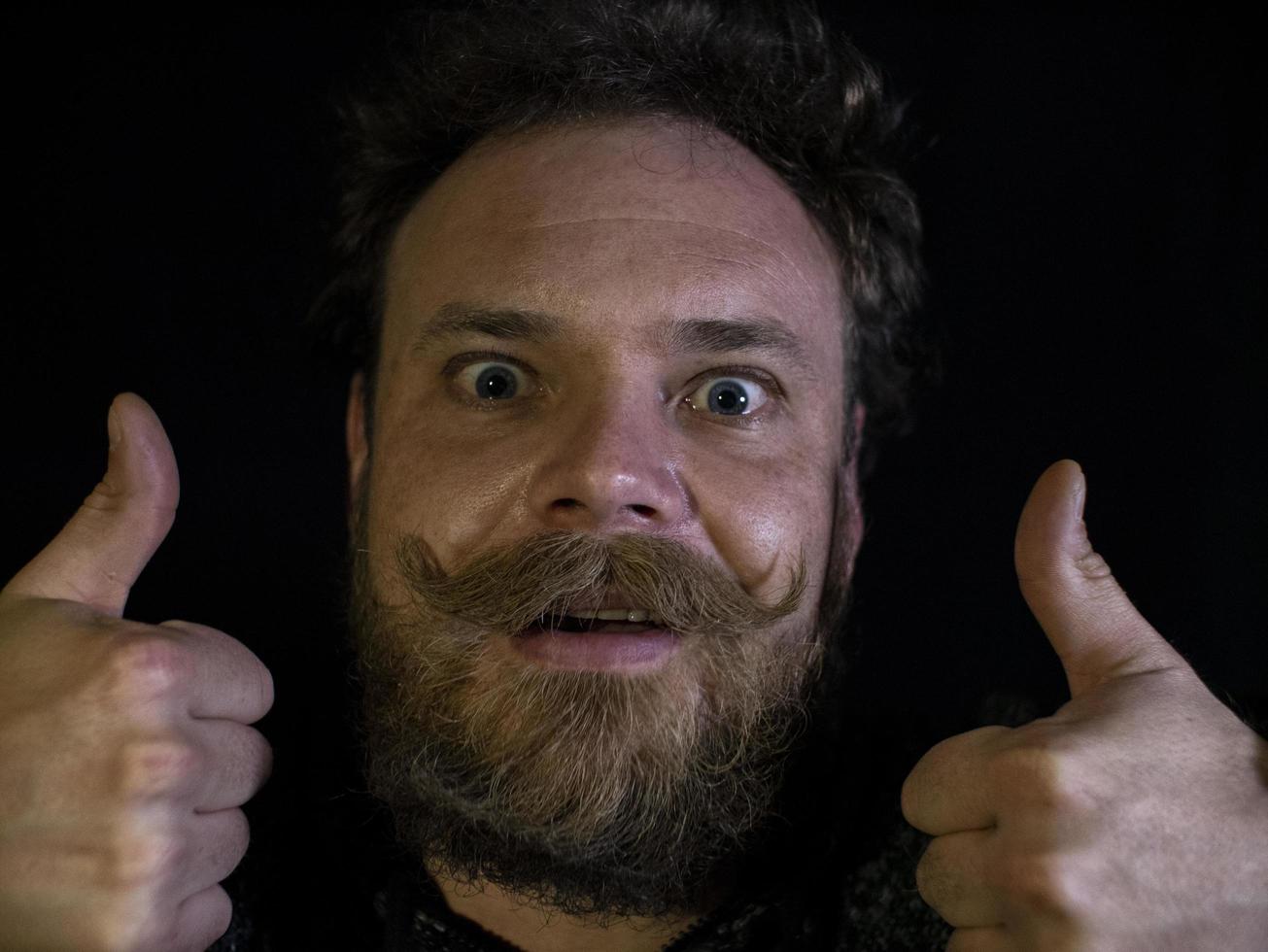 funny face of a man with a beard and mustache showing thumbs up photo