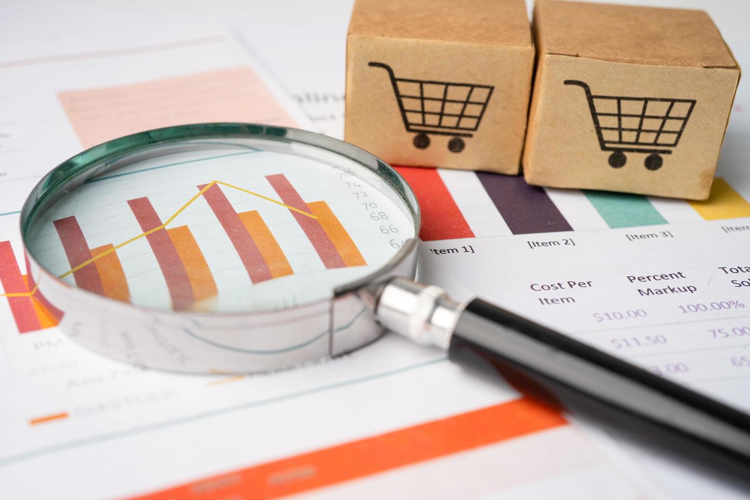 Magnifying glass on charts graphs paper. photo