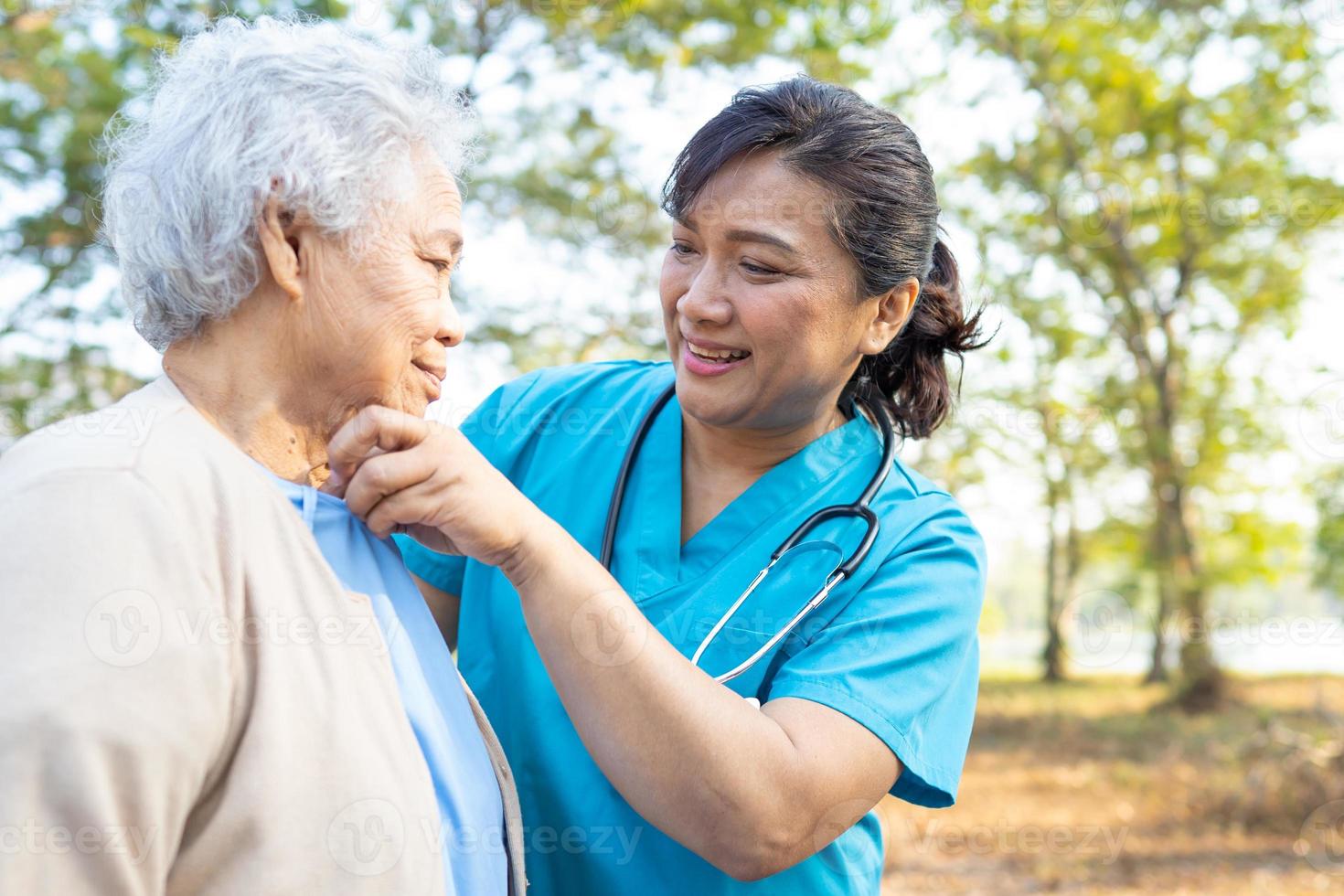 Doctor help and care Asian senior woman walking at park photo