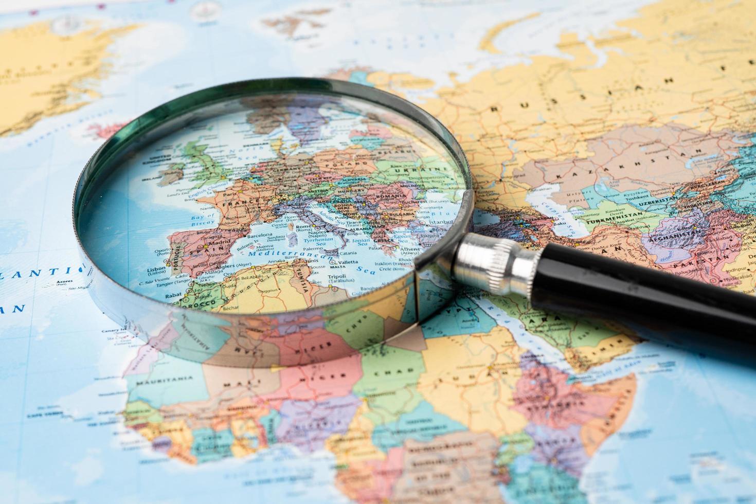 Europe, Magnifying glass close up with colorful world map photo