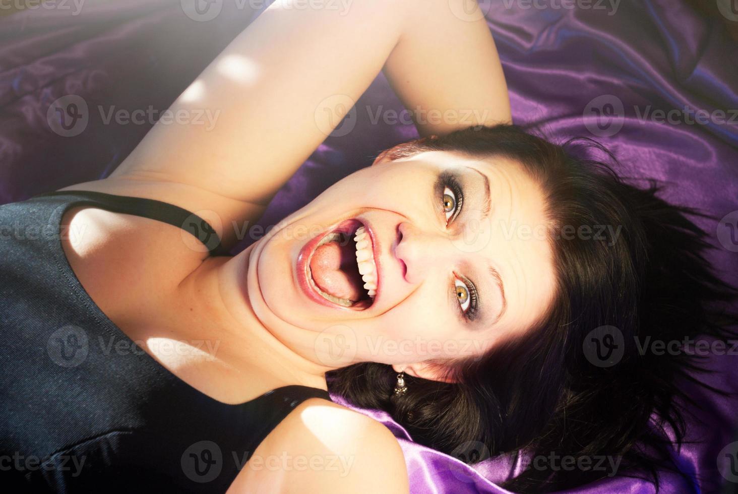 young woman having fun, emotional, lying on bed photo