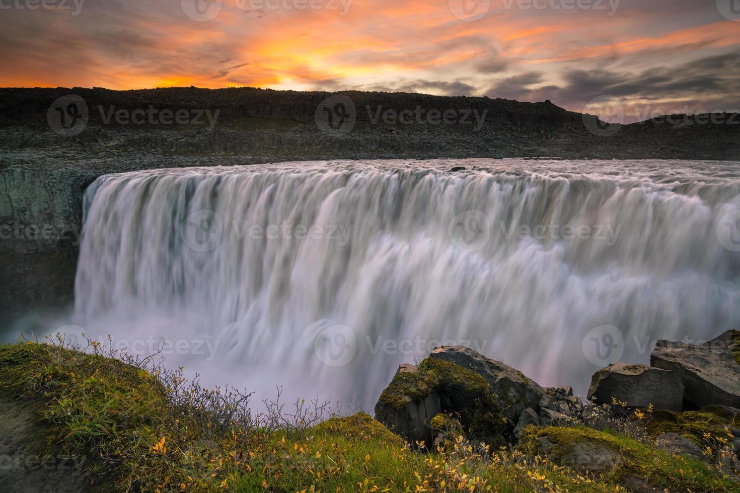 Cascada detifoss con puesta de sol en el fondo foto